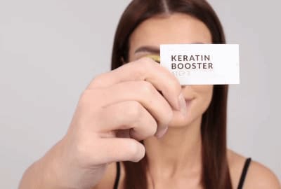 Modell som påfører Step 3 - Keratin Booster på vippene